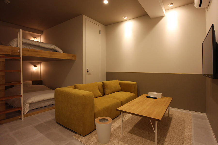 黄色のソファがアクセントの客室-SEKAI HOTEL Nishikujo-
