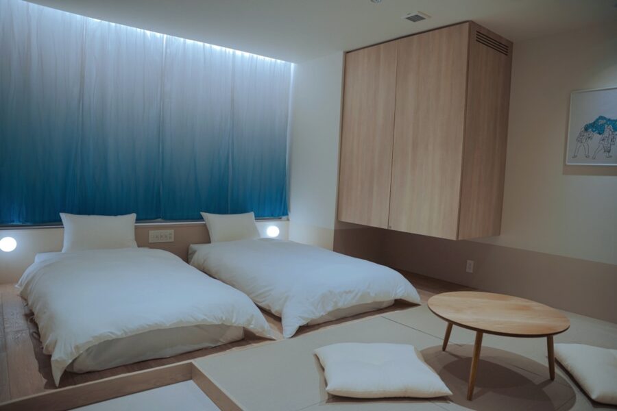 やわらかな青のカーテンが揺れる、ミニマムなホテルデザイン