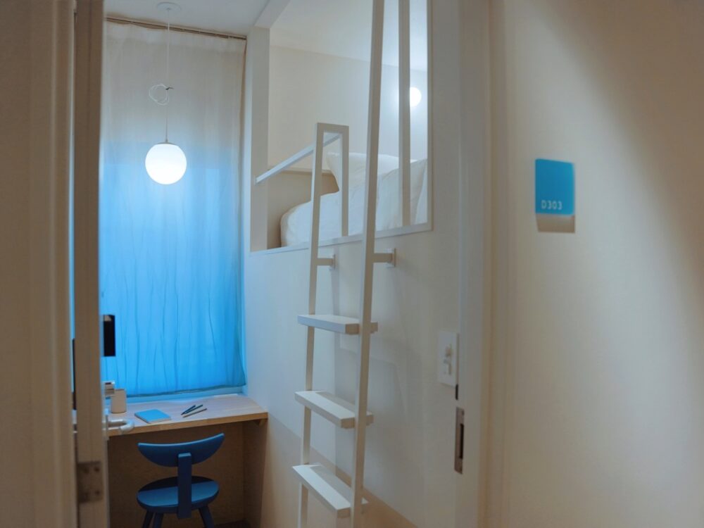 やわらかな青のカーテンが揺れる、ミニマムなホテルデザイン-SEKAI HOTEL Takaoka-